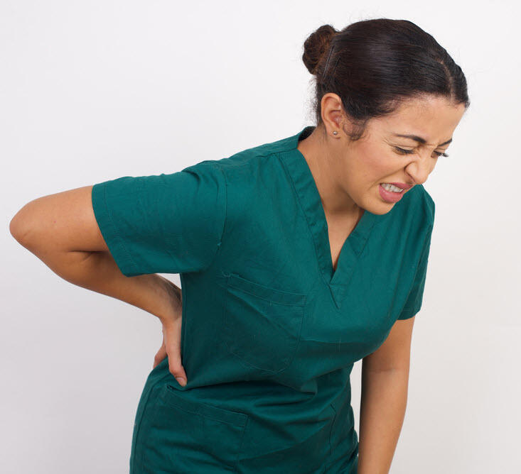 Injured Caregiver A caregiver who has injured her back due to a bad transfer is holding her back and wincing